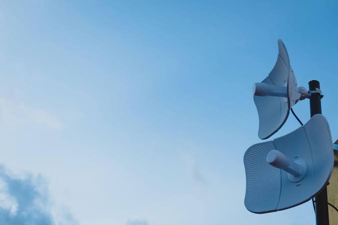 Outdoor wireless bridge dishes mounted against the sky